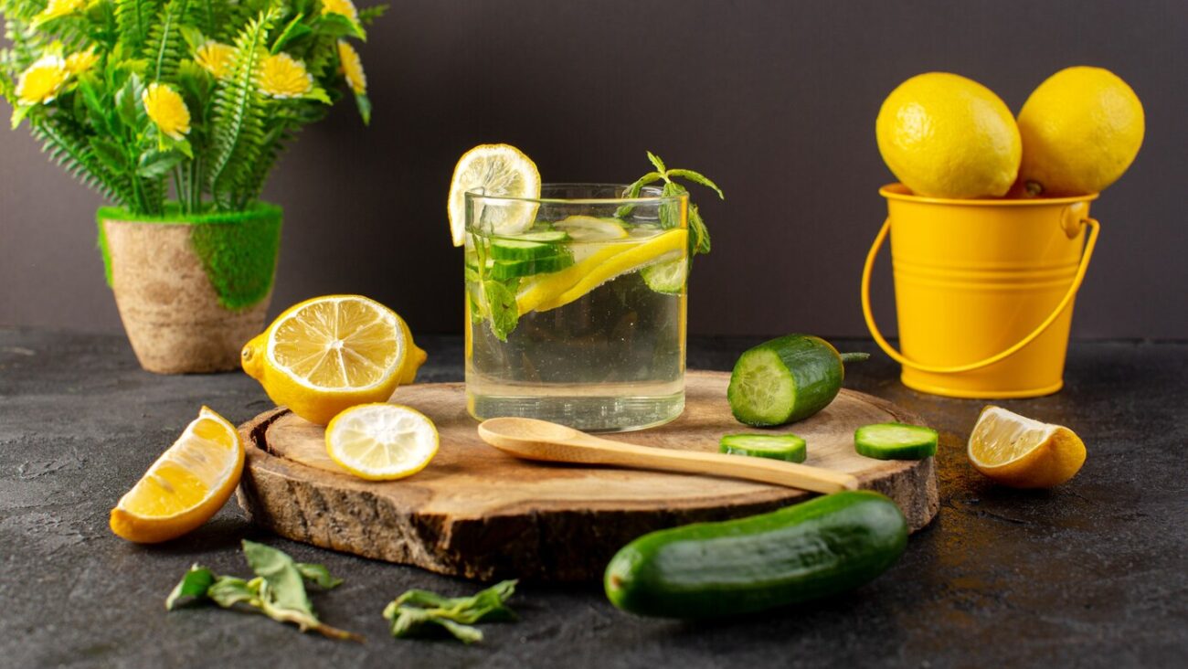 Detox, a glass of water with lemons and cucumbers on a wooden board